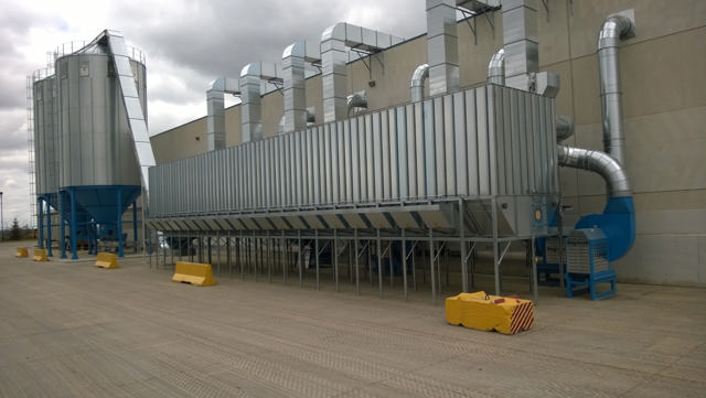 A chain filter with a silo outside of a industrial building 